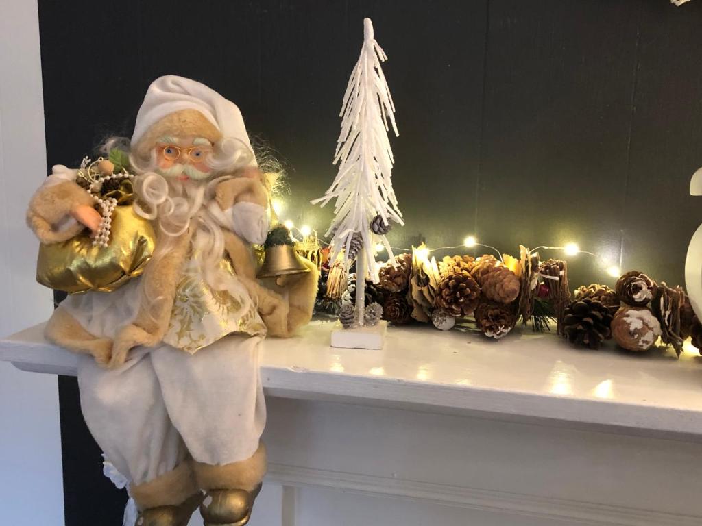 a santa claus sitting on a mantle with christmas decorations at Chalet 2Relax in Zutendaal