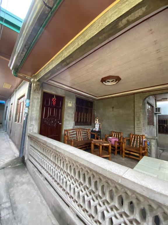 einen Balkon eines Hauses mit einem Tisch und Stühlen in der Unterkunft Perucho-Silang Guest House in Mabini