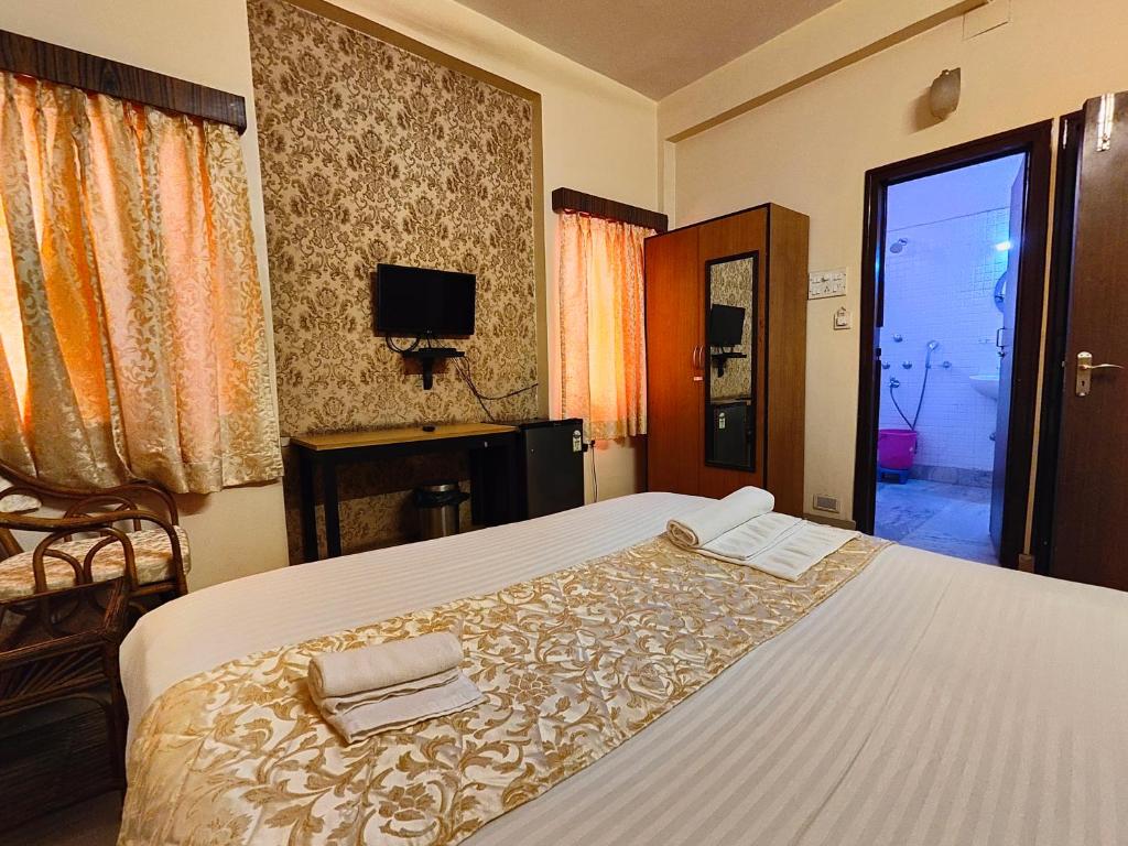 a bedroom with a bed with two towels on it at AMIT HOTEL in Kolkata