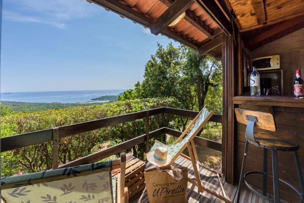 a balcony with a view of the ocean at Camping U Pirellu in Porto-Vecchio