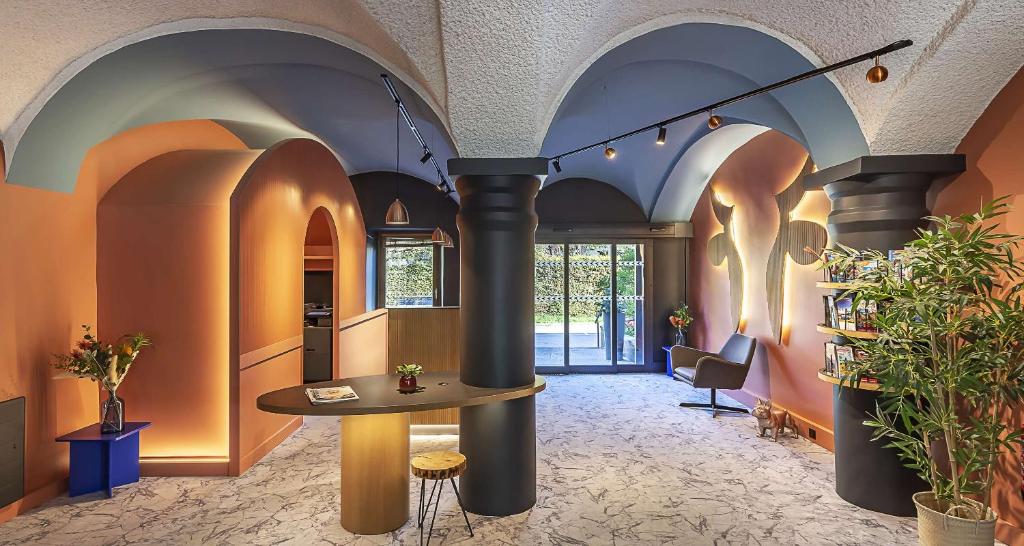 ein Zimmer mit Säulen und einem Tisch in der Mitte in der Unterkunft Sure Hotel by Best Western Annecy in Annecy