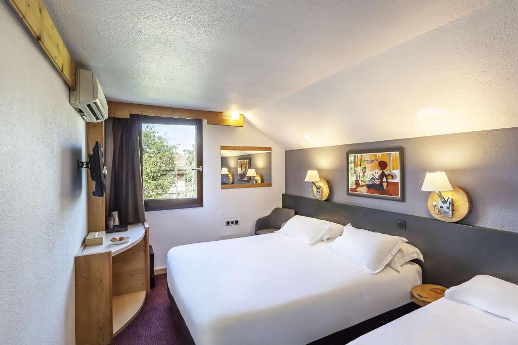 a hotel room with two beds and a window at Sure Hotel by Best Western Annecy in Annecy