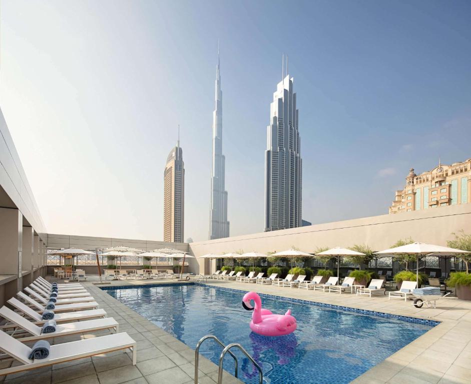 杜拜的住宿－迪拜市中心羅弗酒店，一座城市中一座游泳池,里面装有粉红色的火烈鸟