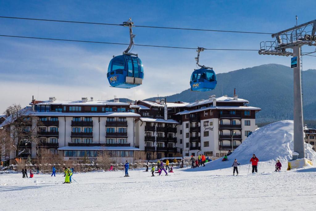 a group of people riding a ski lift in the snow at MPM Hotel Sport Ski-in, Ski-out in Bansko
