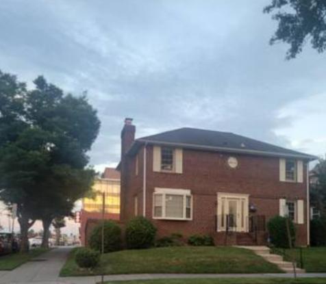 a red brick house with a tree in front of it at Sheppard in Washington