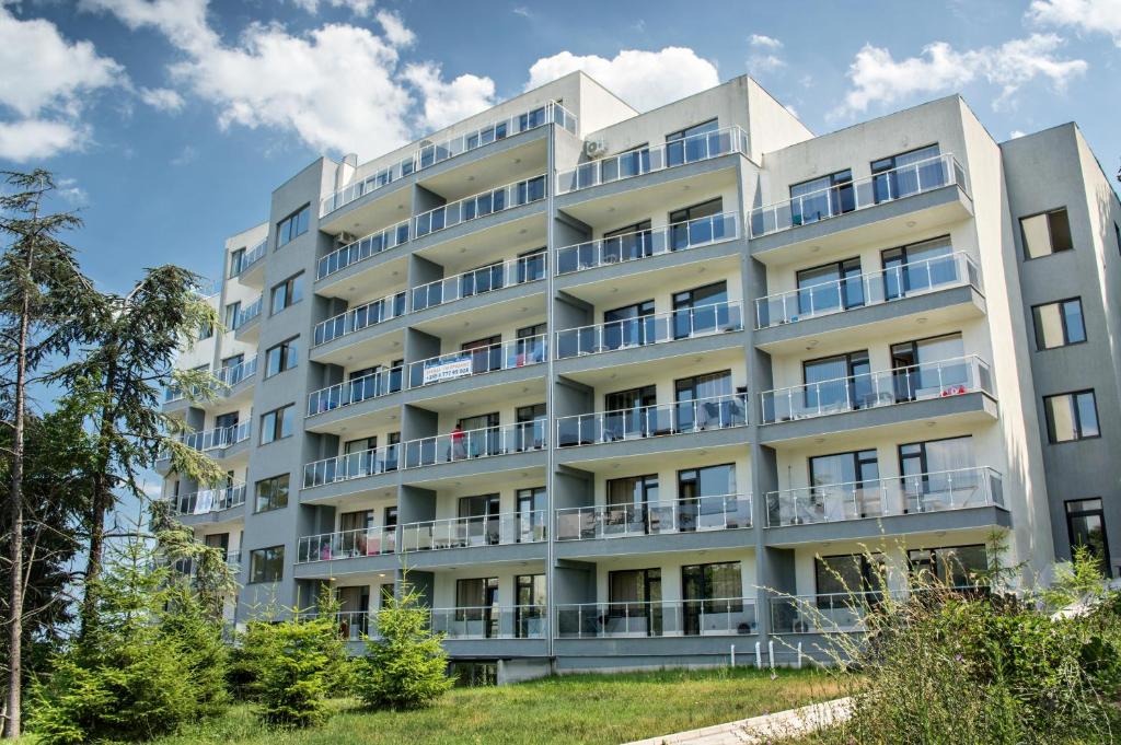 an apartment building with balconies and trees at Ivtour Apartments in Yalta complex in Golden Sands