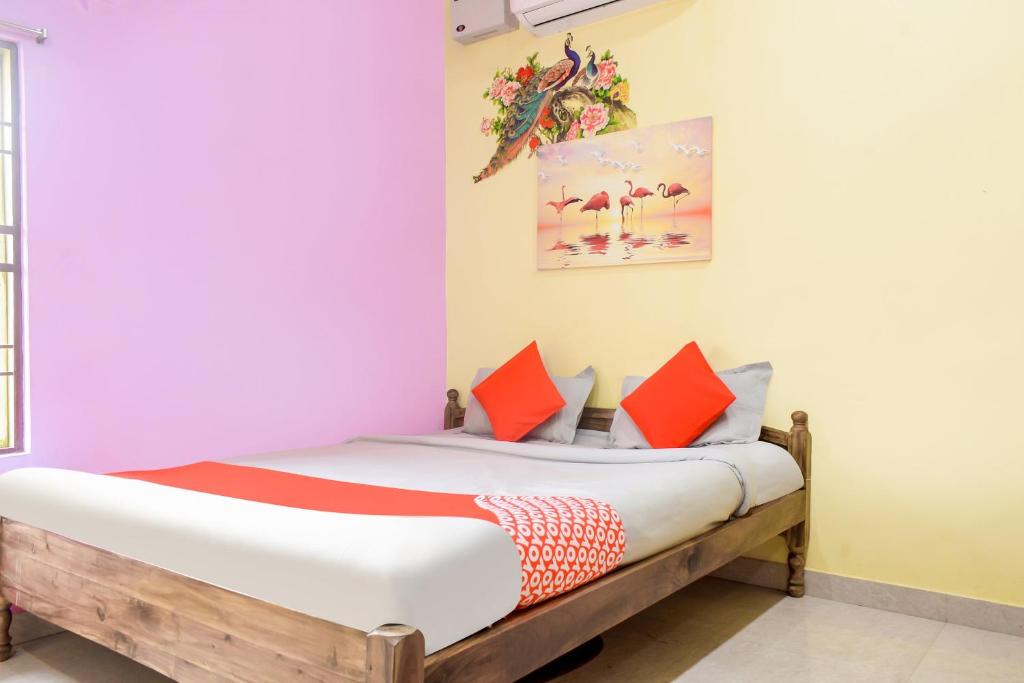 1 dormitorio con 1 cama con almohadas de color naranja en OYO Aradhya Regency, en Konark