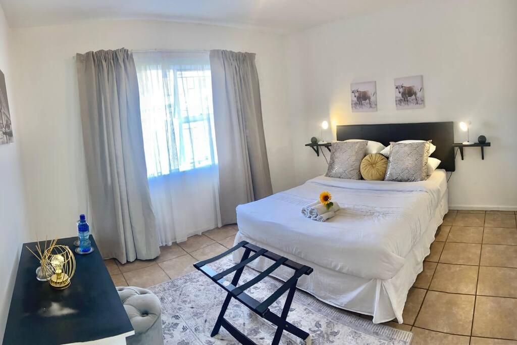 a bedroom with a large white bed and a window at Mall of Africa View in Midrand