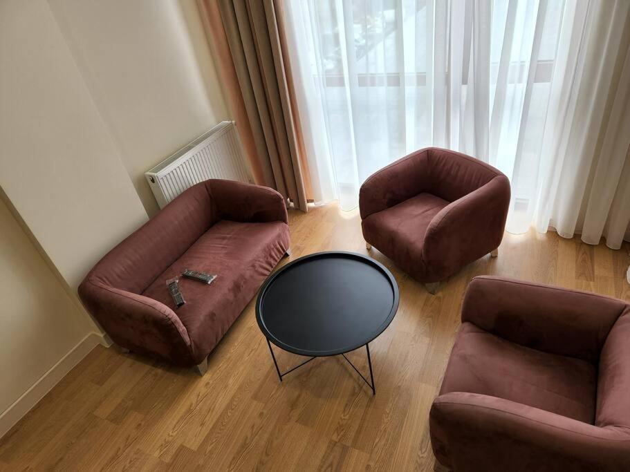 ein Wohnzimmer mit 2 Sofas und einem Tisch in der Unterkunft Tsereteli flatt 7 in Tbilisi City