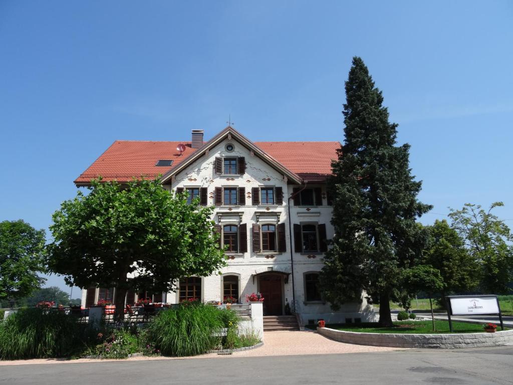 ein großes weißes Haus mit rotem Dach in der Unterkunft Landhaus Vier Jahreszeiten in Eriskirch