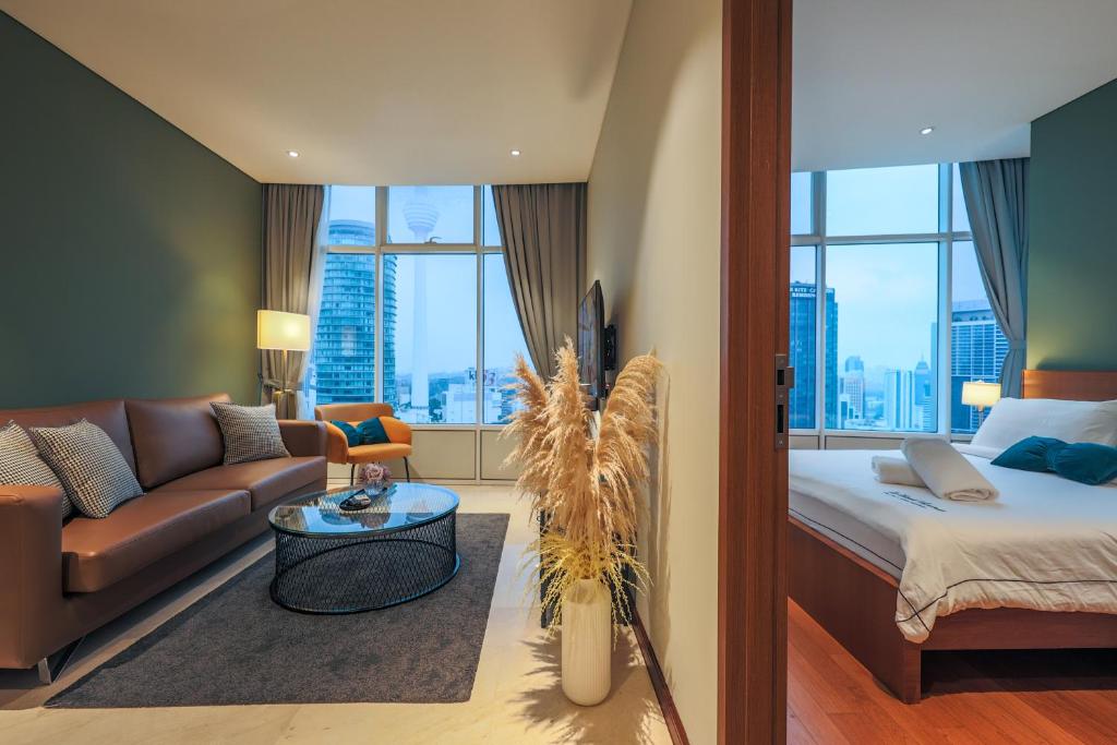 a living room with a bed and a couch at Calm Sojourn, Sky Suites KLCC in Kuala Lumpur
