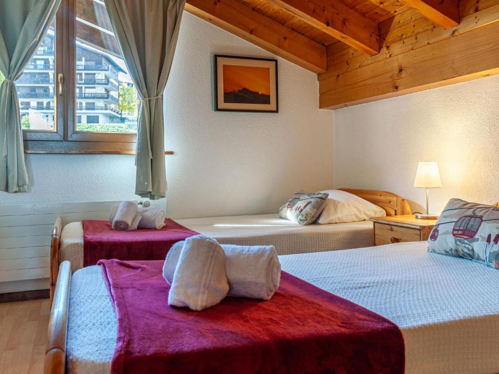 a bedroom with two beds with towels on them at Apartment Anemone 9 by Interhome in Nendaz