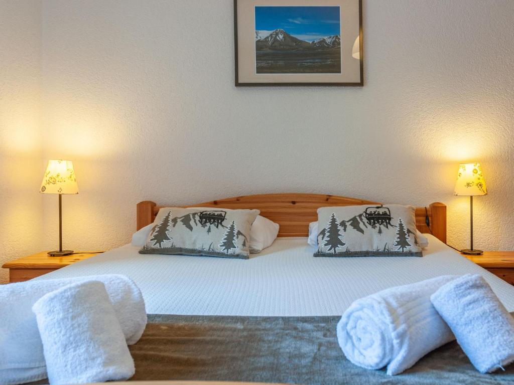 twee bedden in een slaapkamer met twee lampen en handdoeken bij Apartment Anemone 9 by Interhome in Nendaz
