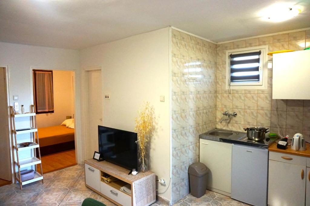 een woonkamer met een keuken en een tv in een kamer bij Serenity by the sea #3 - private terrace in Vrsi
