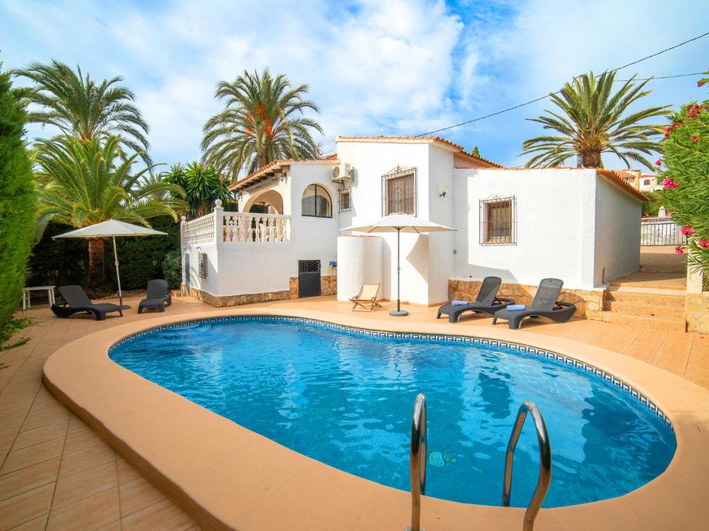 a villa with a swimming pool in front of a house at Holiday Home Mara by Interhome in Casas de Torrat