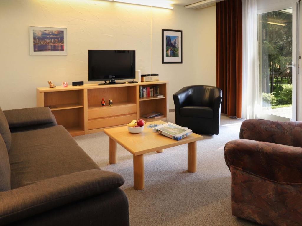 ein Wohnzimmer mit einem TV und einem Couchtisch in der Unterkunft Apartment Allod Park Haus B E01 by Interhome in Davos