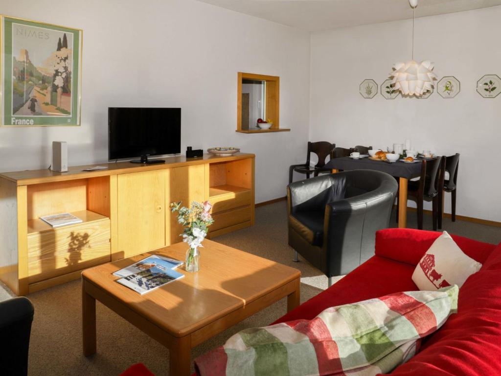 a living room with a couch and a tv at Apartment Allod Park Haus C 601 by Interhome in Davos
