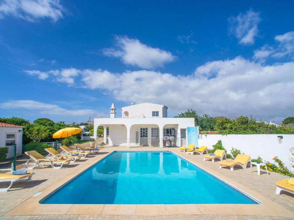 a villa with a swimming pool and lounge chairs at Apartment Quinta Girassol-6 by Interhome in Loulé