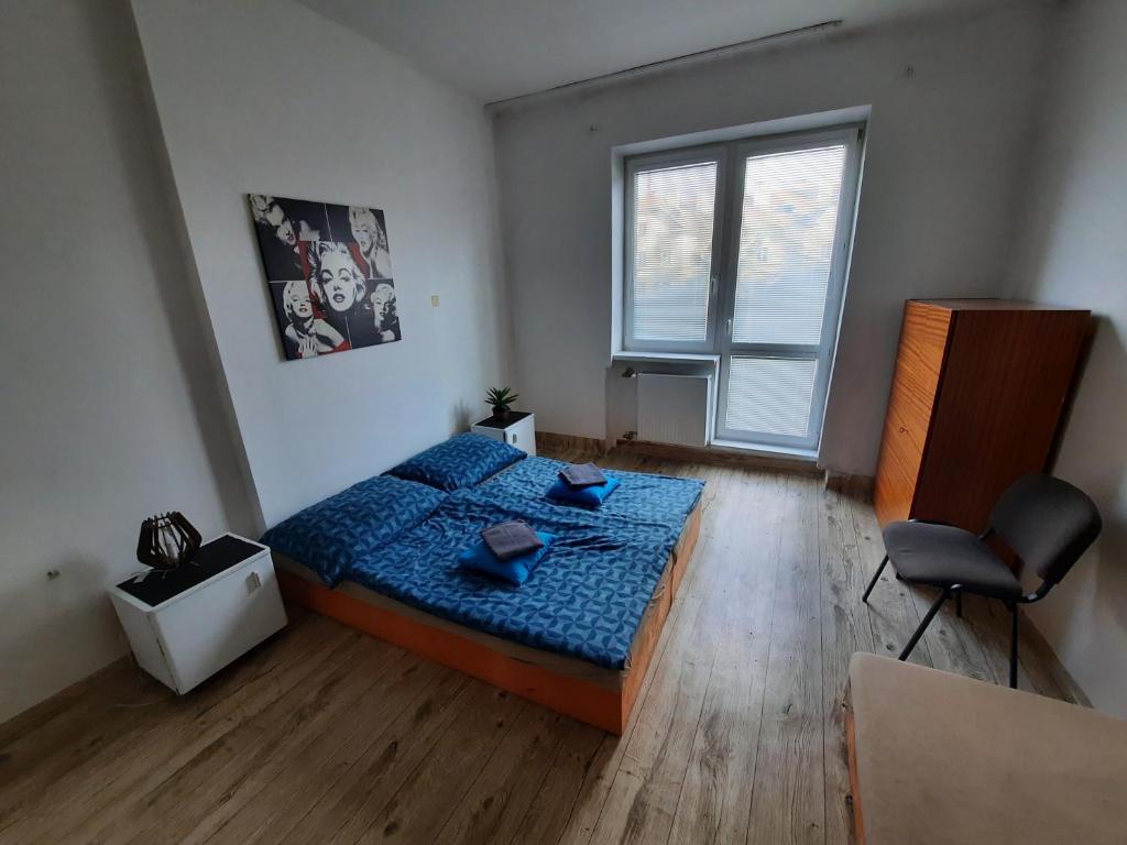 Un dormitorio con una cama azul y una ventana en Cathedral and sights on a budget en Košice