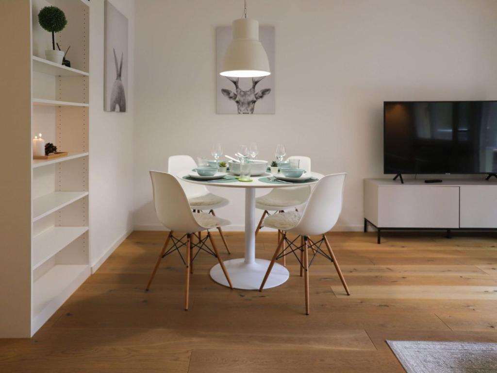 ein Esszimmer mit einem weißen Tisch und Stühlen in der Unterkunft Apartment Allod Park Haus C 202 by Interhome in Davos