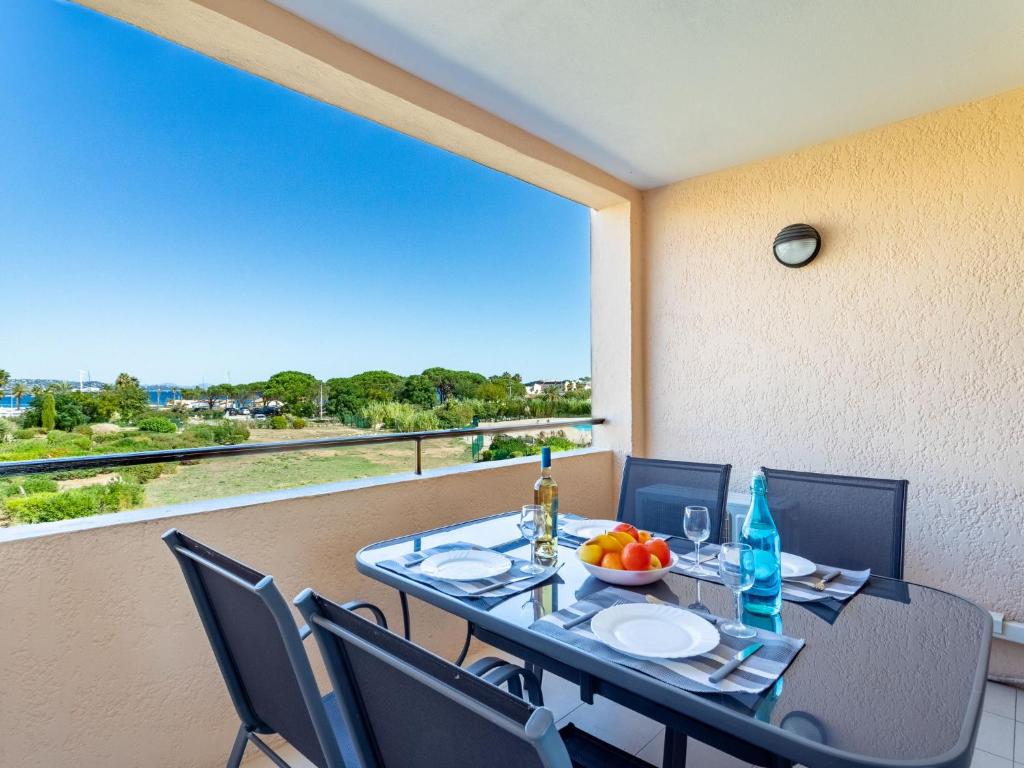 uma mesa de jantar e cadeiras numa varanda com vista em Apartment Les Marines-43 by Interhome em Gassin