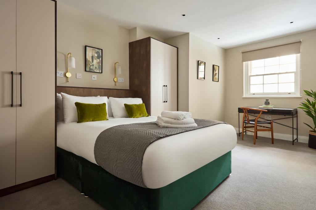 ロンドンにあるChancery Lane by Viridian Apartmentsの大きなベッドと机のある寝室