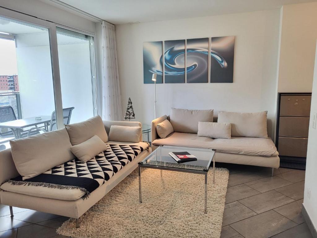 a living room with a couch and a table at Apartment Torre Tessuti Apt-Stefano by Interhome in Locarno
