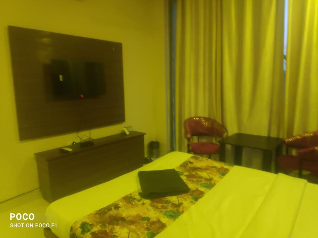 um quarto de hotel com uma cama e uma televisão em Sohan guest house em Chandīgarh