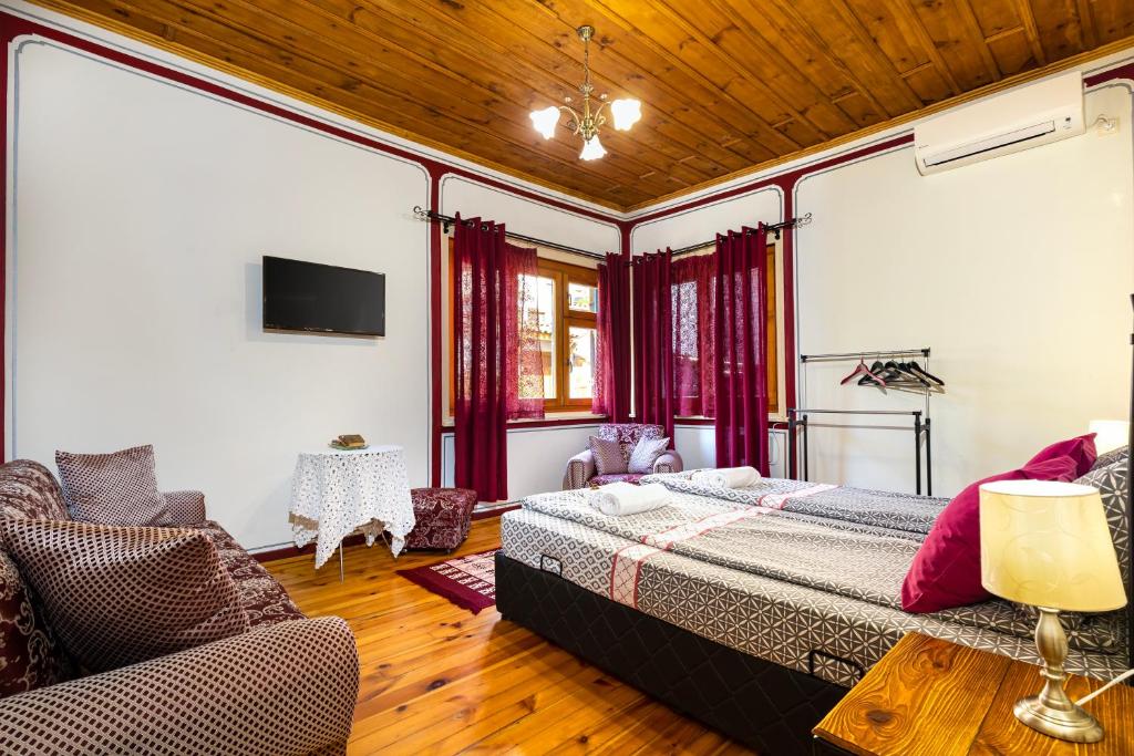 a bedroom with a bed and a couch and a tv at Blacksmith's House - Old Town in Plovdiv