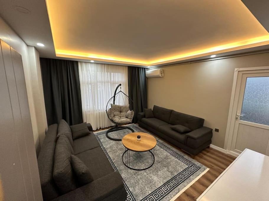 ein Wohnzimmer mit einem Sofa und einem Tisch in der Unterkunft İstanbul Airport House Tayakadın in Arnavutköy