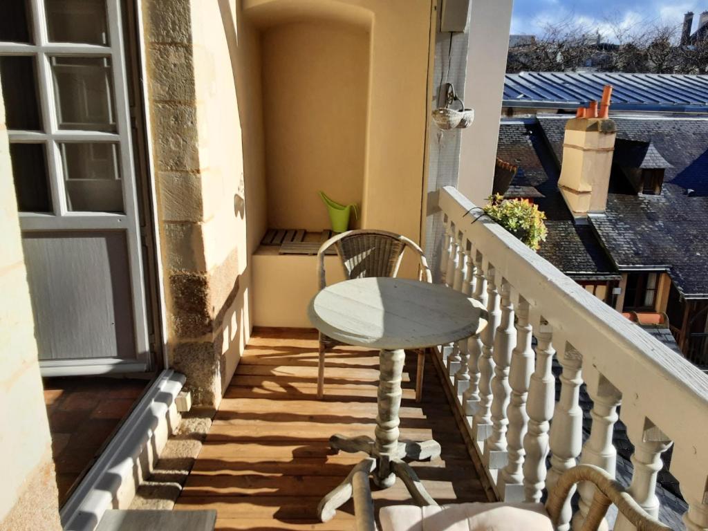 une chaise blanche assise sur les escaliers d'un balcon. dans l'établissement Gite Du Passant Rennais avec balcon sur cour, à Rennes