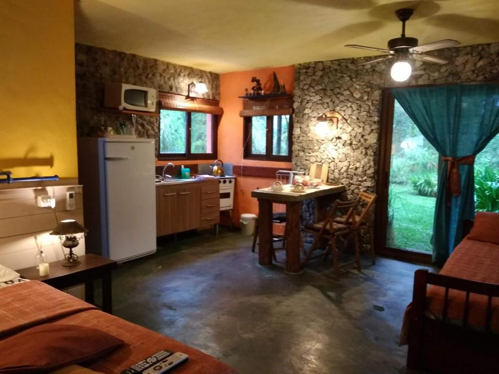 a kitchen with a small table and a refrigerator at El viento en los sauces in Sauce de Portezuelo