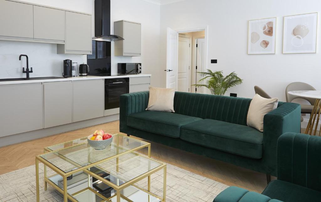 The Salisbury - Luxury Apartments by Stay In Scarborough في سكرابورو: غرفة معيشة مع أريكة خضراء وطاولة