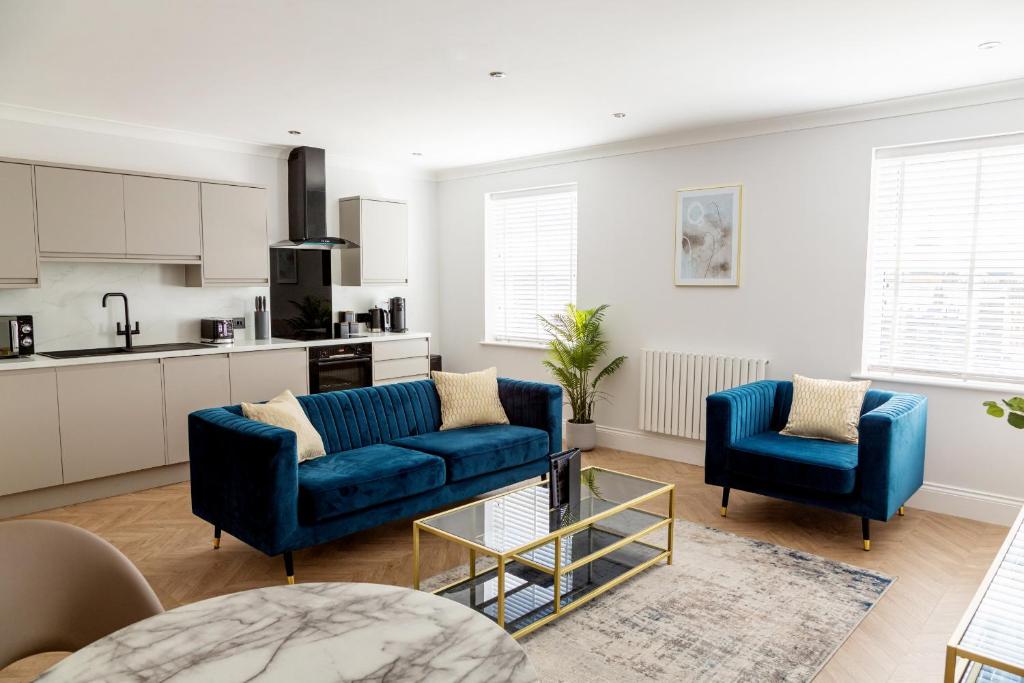 斯卡伯勒The Salisbury - Luxury Apartments by Stay In Scarborough的一间带2张蓝色沙发的客厅和一间厨房