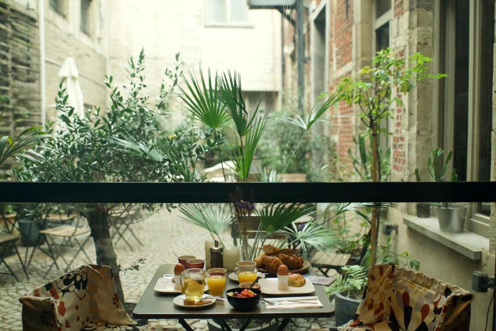 a table with food and drinks on a balcony at Hotel Matelote in Antwerp