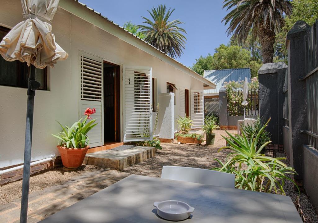 a patio with a table and a house at The River Guestroom in Krugersdorp