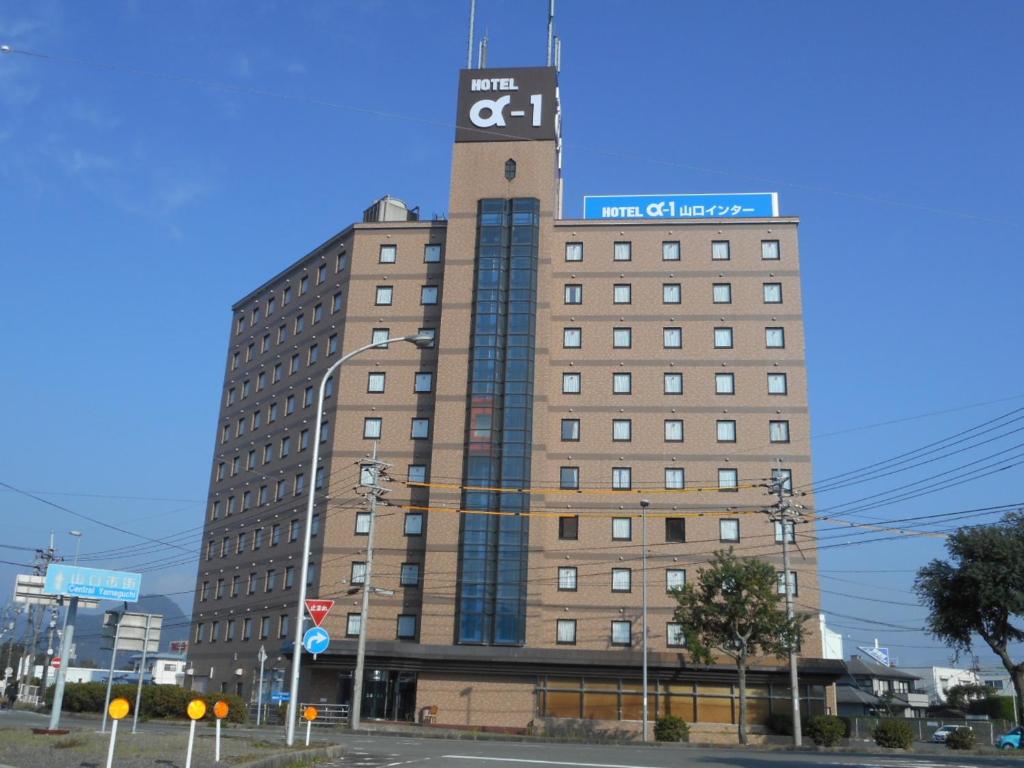 een hoog gebouw met een klokkentoren erop bij Hotel Alpha-One Yamaguchi Inter in Yamaguchi