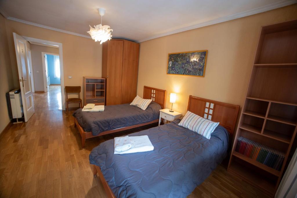 a hotel room with two beds and a living room at CASA DOVELA in Jarandilla de la Vera