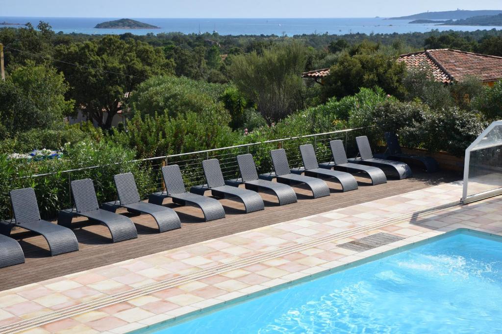 a row of lounge chairs next to a swimming pool at Résidence Chiar' Di Luna in Sainte-Lucie de Porto-Vecchio