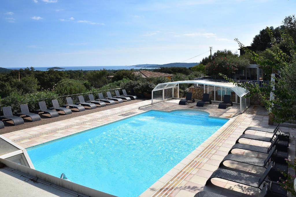 a swimming pool with chaise lounge chairs and a swimming pool at Résidence Chiar&#39; Di Luna in Sainte-Lucie de Porto-Vecchio