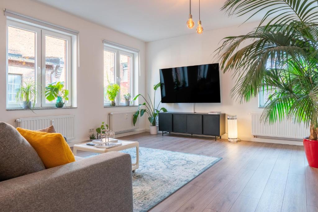 a living room with a flat screen tv on a wall at Luxuriöses Apartment, 10min Innenstadt, Parkplatz in Erfurt