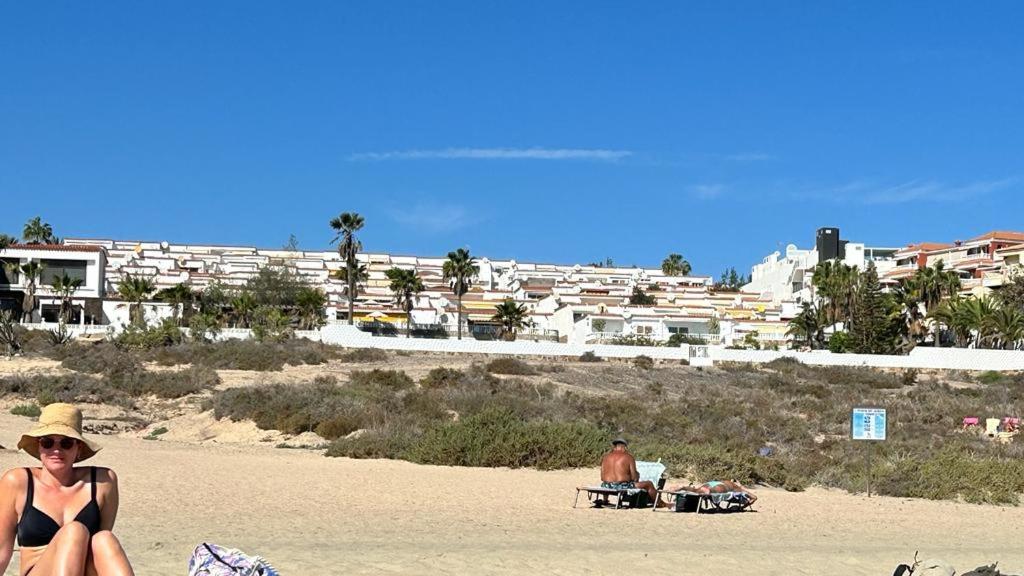 une femme en bikini assise sur la plage dans l'établissement Apartamentos Bahia Playa. Costa Calma., à Costa Calma