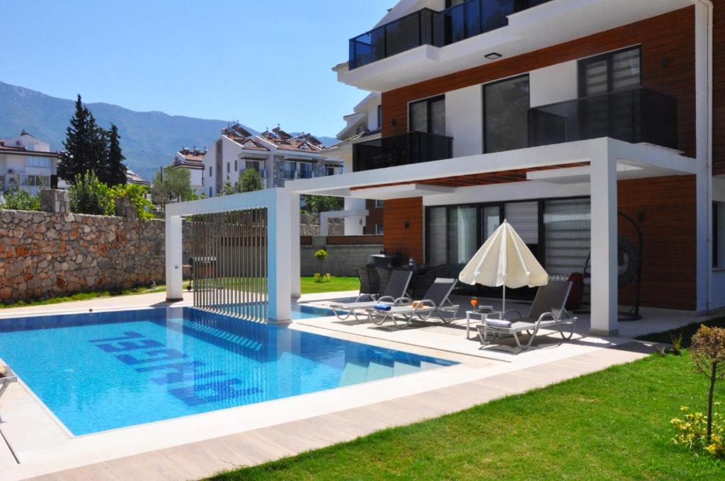een zwembad in de achtertuin van een huis bij Hisar Prestige D in Fethiye