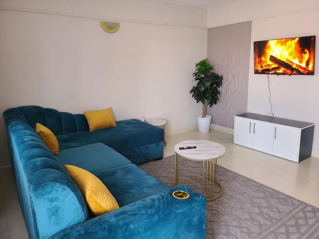 a blue couch in a living room with a fireplace at Wike Suites in Nakuru