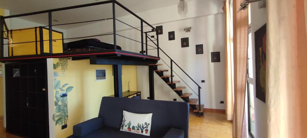 uma sala de estar com um sofá azul e uma escada em la casa di amy - loft corvetto em Milão