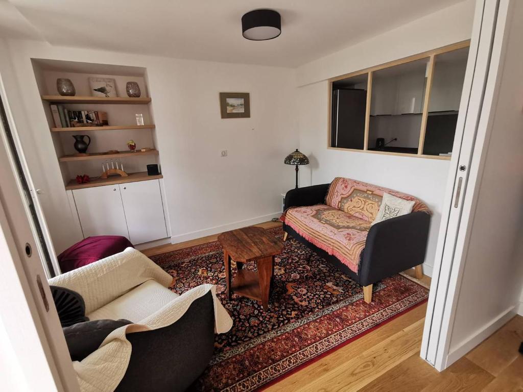 un salon avec un canapé et une chaise dans l'établissement Saint-Jean de Luz, centre historique, apt 4 pièces - 6 couchages, à Sainte-Barbe