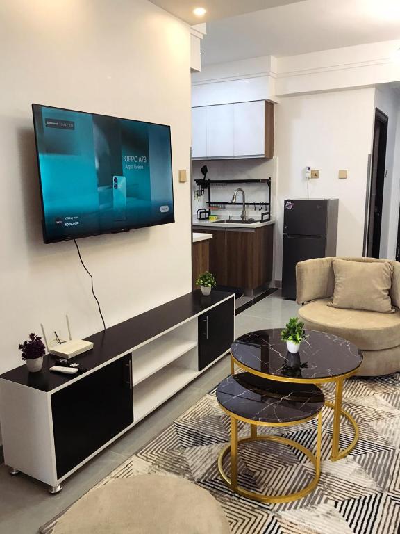un soggiorno con divano e TV a parete di Furnished apartment in Lavington a Nairobi