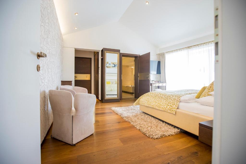 ein Schlafzimmer mit einem Bett und ein Wohnzimmer in der Unterkunft Iris Porsche Hotel & Restaurant in Mondsee