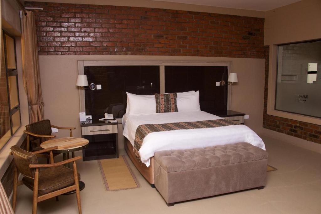 een slaapkamer met een groot bed en een bakstenen muur bij Exquisite executive room for 2 - 2179 in Kingsmead