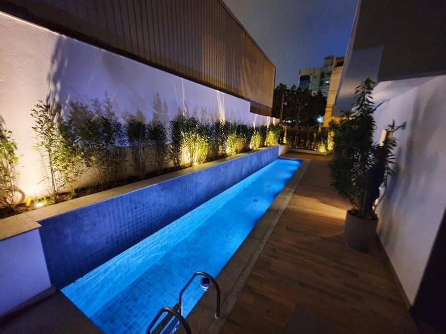 een zwembad in het midden van een gebouw 's nachts bij Apartamento 2 Suítes com piscina e churrasqueira, ao lado da UFSC in Florianópolis